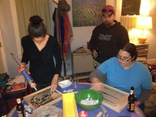 The group tackles mosaicing. Hope handles the silicone, Sam lays out her pattern, and Nate looks on in interest.